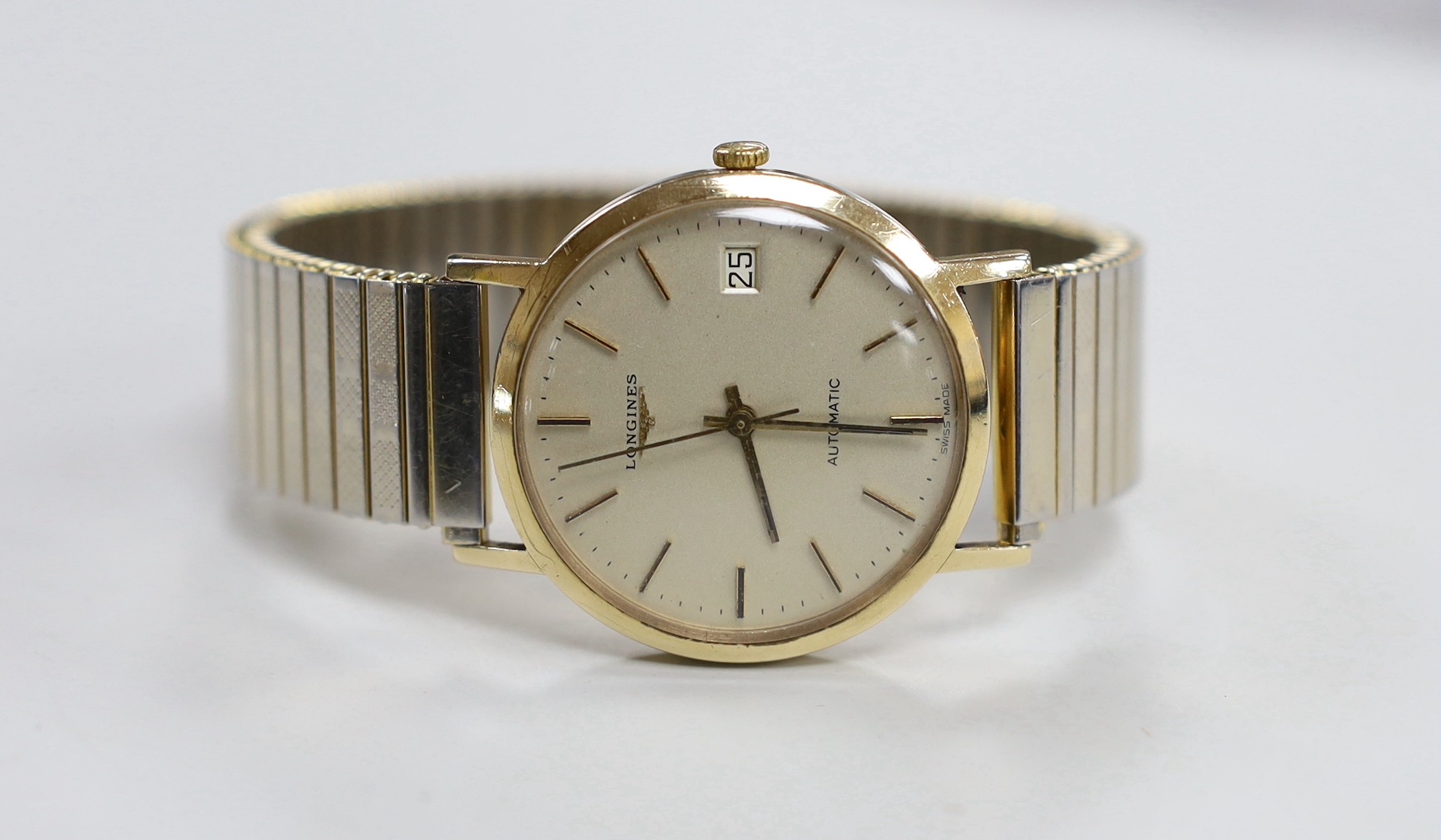 A gentleman's 9ct gold Longines automatic wrist watch, with date aperture, on associated gold plated bracelet, case diameter 35mm.